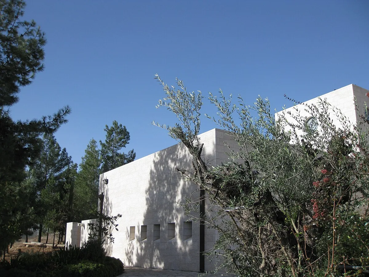The white stone building of the Gush Etzion Winery among pine and olive trees