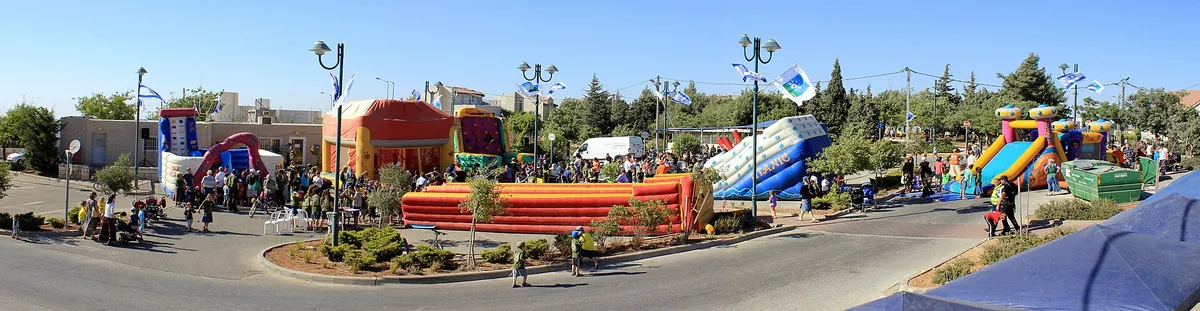 A community fair with inflatable slides on a plaza in Neve Daniel