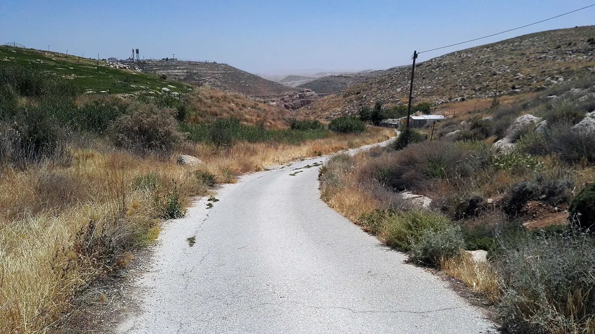 A narrow road leading down from Tekoa into the dry hills of Nahal Tekoa